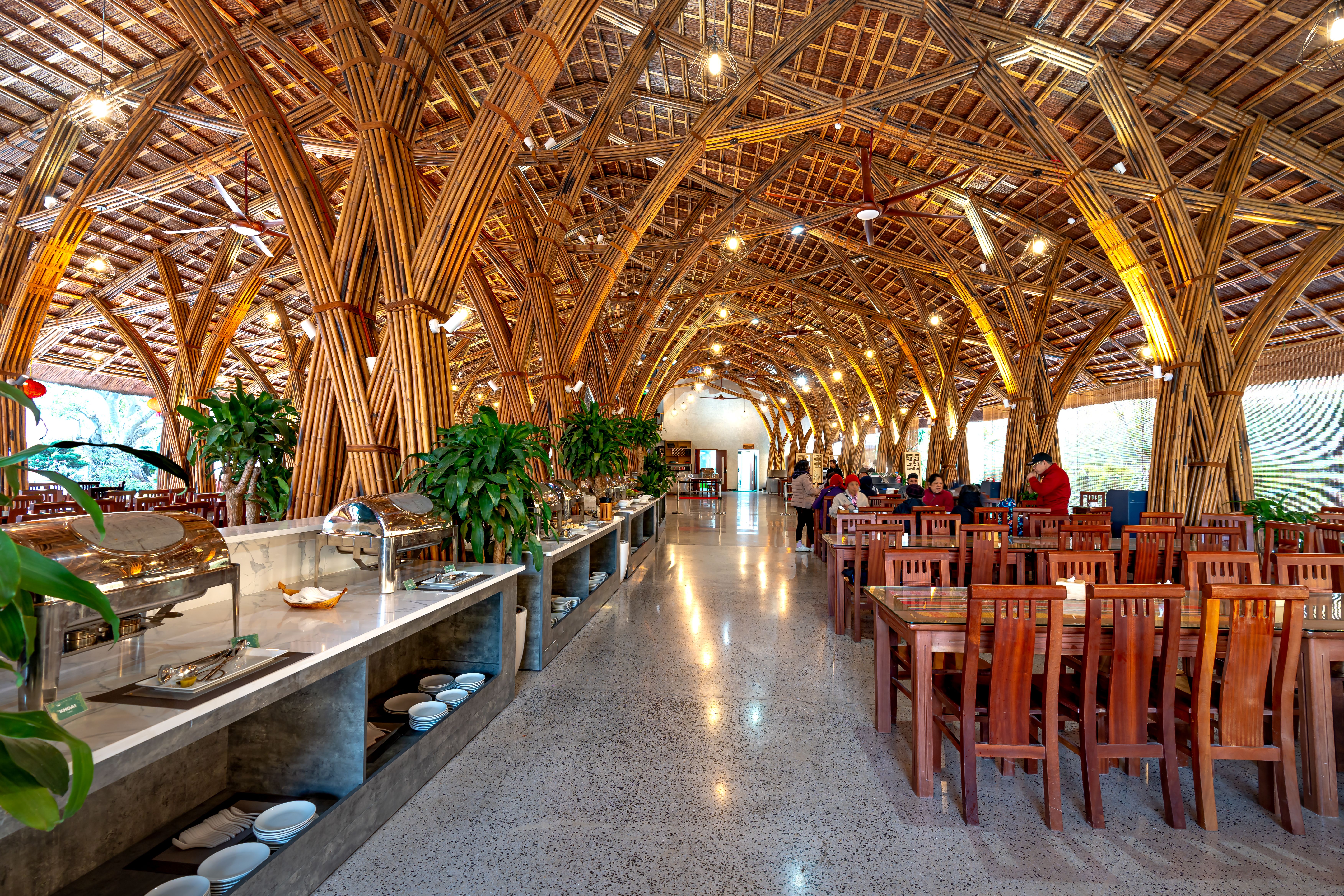 Bamboo-themed restaurant interior with wooden furniture and natural materials, conveying an eco-conscious dining atmosphere.