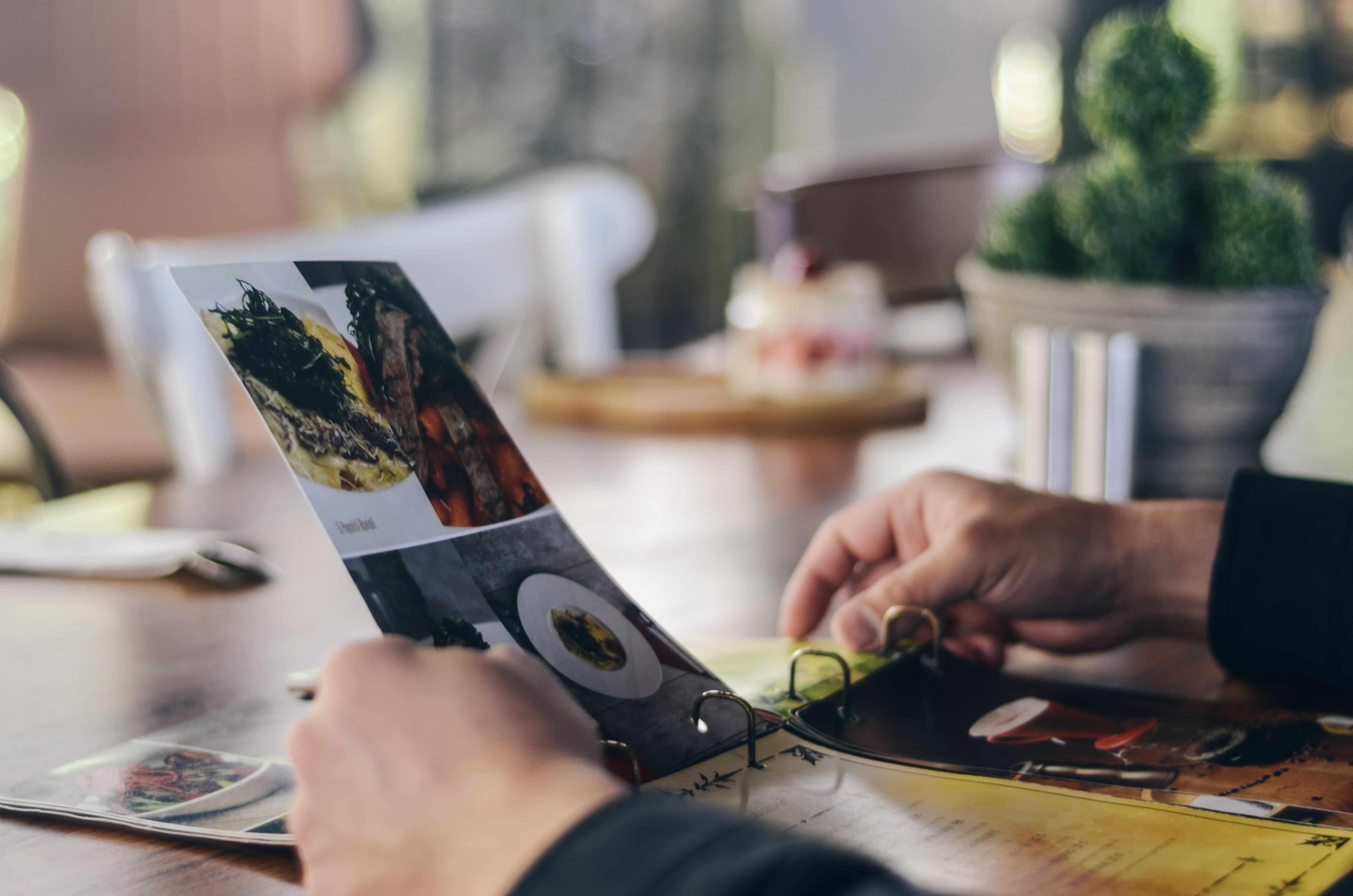 Diner looking through a restaurant menu, representing how sustainability and solar commitments can be communicated to guests.